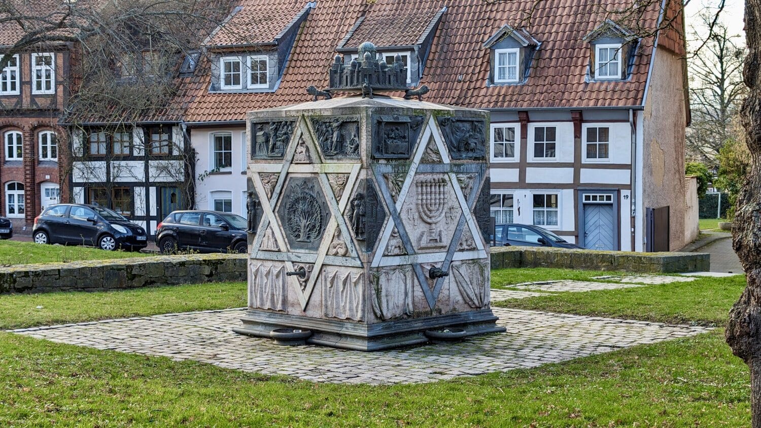 Mahnmal mit Fachwerkhaus im Hintergrund